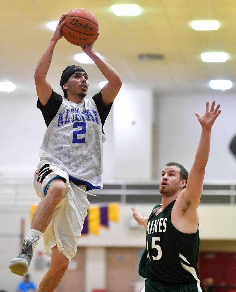 Klukwans Austin Shoemaker lays the ball up over Haines Brian Combs in a B bracket game at the Juneau Lions Club 73rd Annual Gold Medal Basketball Tournament at Juneau-Douglas High School: Yadaa.at Kalé on Tuesday, March 19, 2019. Haines won 97-51. (Michael Penn | Juneau Empire)