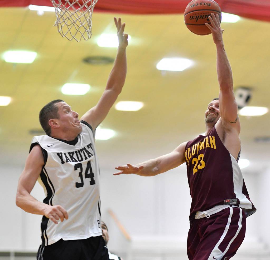Klukwans Michael Ganey, right, shoots over Yakutats Jimmi Jensen at the Juneau Lions Club 73rd Annual Gold Medal Basketball Tournament at Juneau-Douglas High School: Yadaa.at Kalé on Tuesday, March 19, 2019. Klukwan won 94-61. (Michael Penn | Juneau Empire)