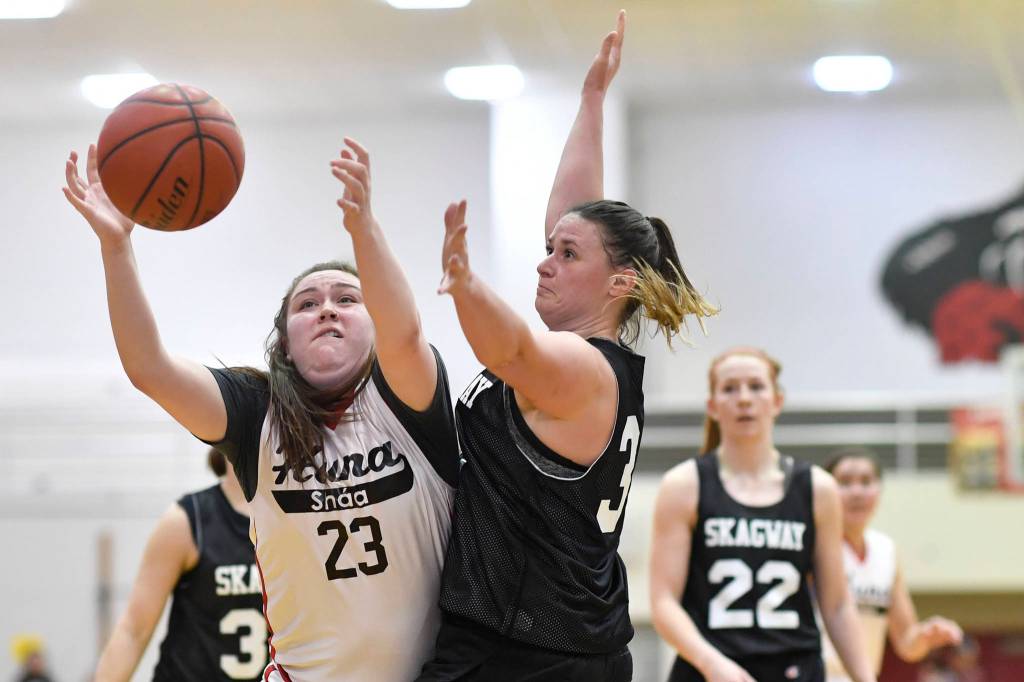 Hoonahs Mariah Martin, left, is guarded closely by Skagways Tiffanie Ames at the Juneau Lions Club 73rd Annual Gold Medal Basketball Tournament at Juneau-Douglas High School: Yadaa.at Kalé on Tuesday, March 19, 2019. Skagway won 80-42. (Michael Penn | Juneau Empire)