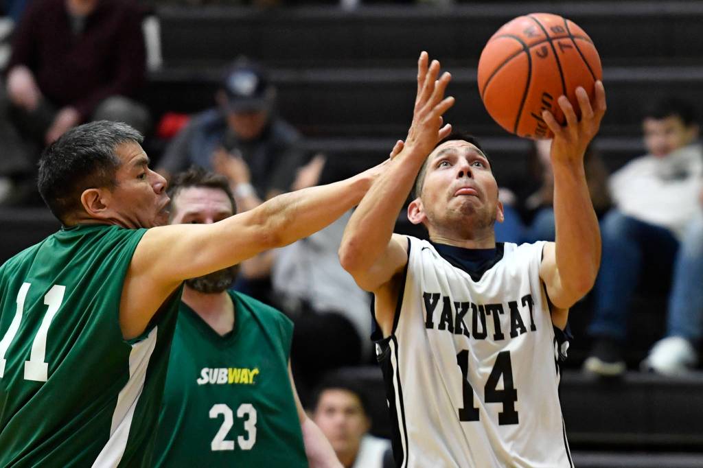 Yakutats Ralph Johnson, left, shoots against Sitkas Ray Kitka in a masters bracket game at the Juneau Lions Club 73rd Annual Gold Medal Basketball Tournament at Juneau-Douglas High School: Yadaa.at Kalé on Wednesday, March 20, 2019. Yakutat won 66-49. (Michael Penn | Juneau Empire)