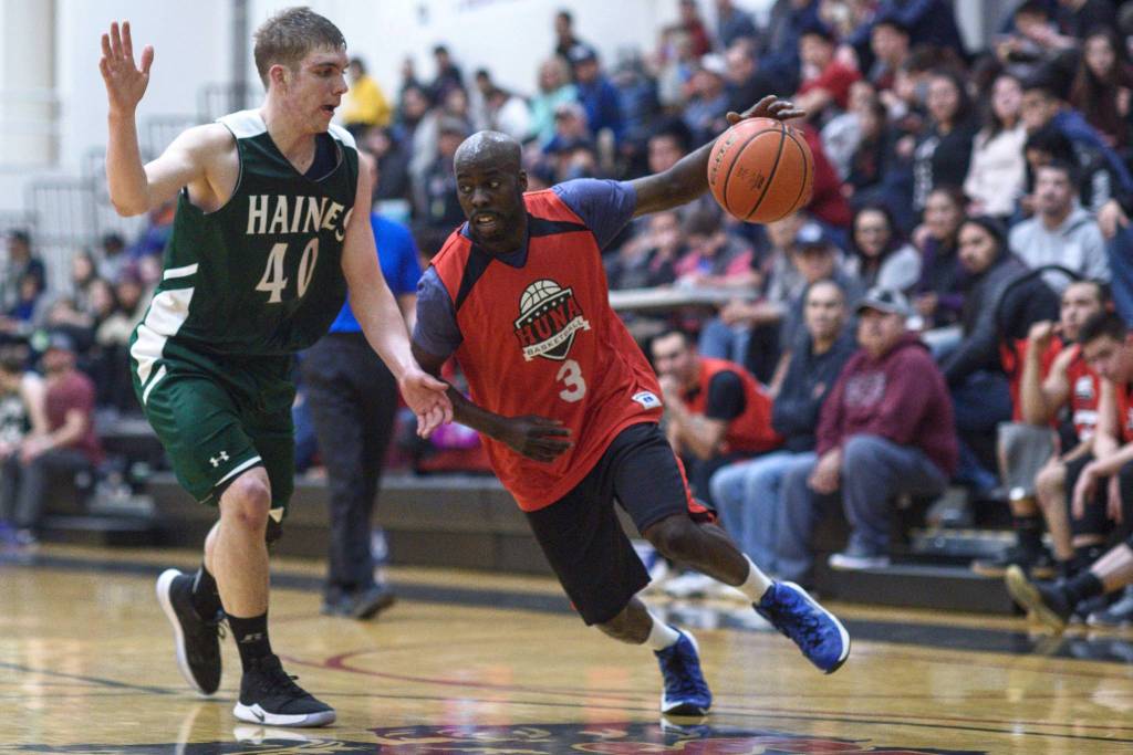 Hoonahs Justen Samuels, right, drives against Haines Dylon Swinton in a B bracket game at the Gold Medal Basketball Tournament on Wednesday, March 20, 2019. (Michael Penn | Juneau Empire)