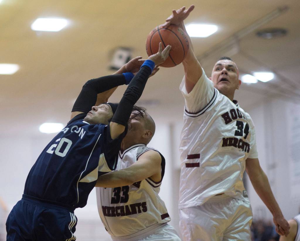 Angoons Sterling Bolima, left, has his shot blocked by Hoonahs Louie White Sr., center, and James Mercer in a masters bracket game at the Juneau Lions Club 73rd Annual Gold Medal Basketball Tournament at Juneau-Douglas High School: Yadaa.at Kalé on Wednesday, March 20, 2019. Hoonah won 75-44. (Michael Penn | Juneau Empire)