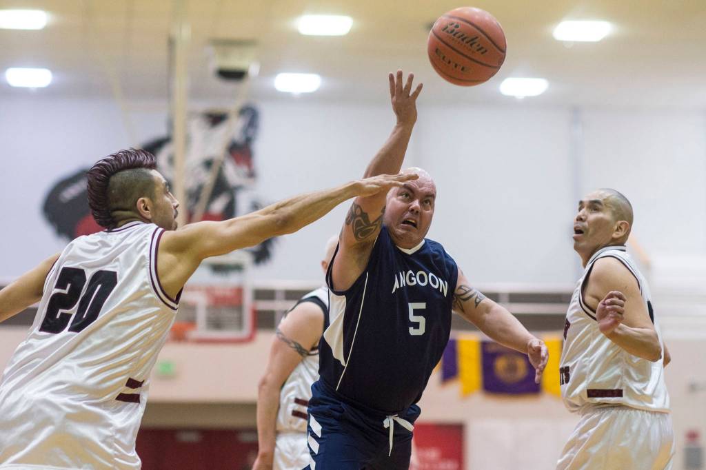 Angoons Paul Johnson, center, lays the ball up between Hoonahs Marti Fred, left, and Louie White Sr. in a masters bracket game at the Juneau Lions Club 73rd Annual Gold Medal Basketball Tournament at Juneau-Douglas High School: Yadaa.at Kalé on Wednesday, March 20, 2019. Hoonah won 75-44. (Michael Penn | Juneau Empire)