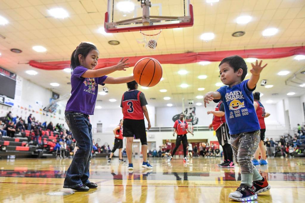 Paul Hyatt, 2, plays with his sister, Alayna, 5, as Kake and Haines women warm up for their game at the Juneau Lions Clubs Gold Medal Basketball Tounament at JDHS on Wednesday, March 20, 2019. (Michael Penn | Juneau Empire)