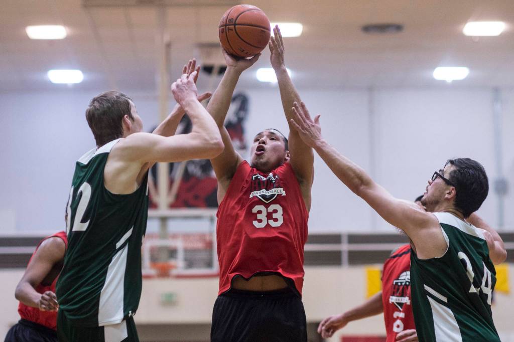 Hoonahs Jaylin Prince, center, shoots over Haines Tyler Swinton, left, and James Hart in a B bracket game at the Juneau Lions Club 73rd Annual Gold Medal Basketball Tournament at Juneau-Douglas High School: Yadaa.at Kalé on Wednesday, March 20, 2019. Haines won 71-32. (Michael Penn | Juneau Empire)