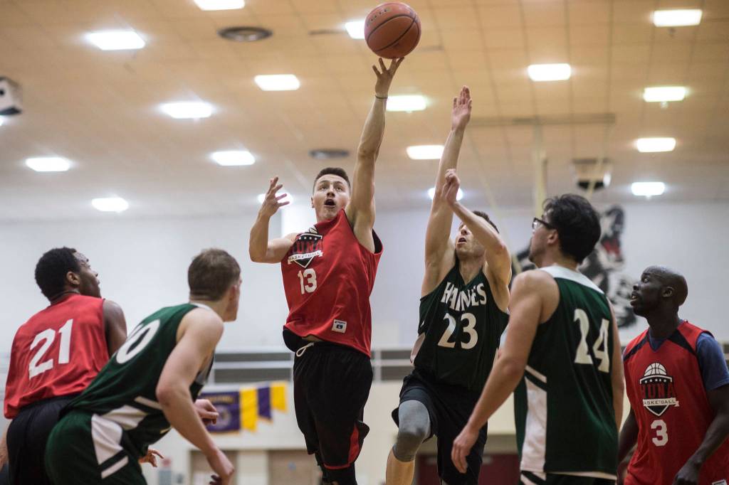 Hoonahs Michael Croasmun, center, shoots against Haines Ryan Olsen in a B bracket game at the Juneau Lions Club 73rd Annual Gold Medal Basketball Tournament at Juneau-Douglas High School: Yadaa.at Kalé on Wednesday, March 20, 2019. Haines won 71-32. (Michael Penn | Juneau Empire)