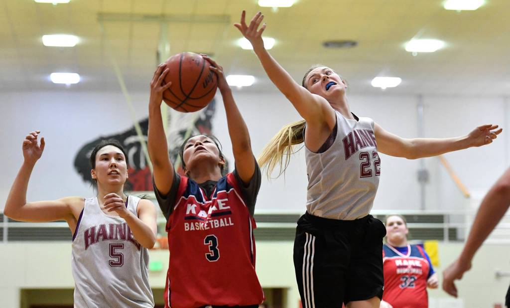Kakes Monique Ybarra, center, rebounds between Haines Fran Daly, left, and Liz Segars at the Juneau Lions Club 73rd Annual Gold Medal Basketball Tournament at Juneau-Douglas High School: Yadaa.at Kalé on Wednesday, March 20, 2019. Haines won 67-20. (Michael Penn | Juneau Empire)