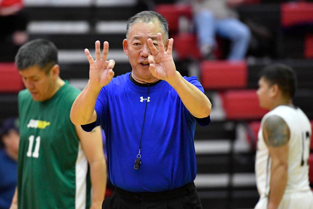 Referee Craig Tamaki signs a foul during a masters bracket game of Yakutat against Sitka at the Juneau Lions Club 73rd Annual Gold Medal Basketball Tournament at Juneau-Douglas High School: Yadaa.at Kalé on Wednesday, March 20, 2019. Tamaki has come back to referee the tournament since 2011. (Michael Penn | Juneau Empire)