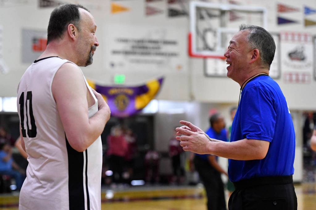 Referee Craig Tamaki, right, shares a laugh with Yakutats Greg Indreland during a masters bracket game against Sitka at the Juneau Lions Club 73rd Annual Gold Medal Basketball Tournament at Juneau-Douglas High School: Yadaa.at Kalé on Wednesday, March 20, 2019. Tamaki has come back to referee the tournament since 2011. (Michael Penn | Juneau Empire)
