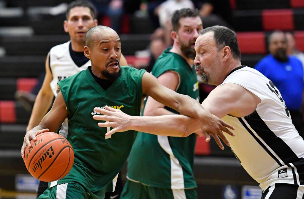 Sitkas Jeff Richards, left, drives against Sitkas Greg Indreland in a masters bracket game at the Juneau Lions Club 73rd Annual Gold Medal Basketball Tournament at Juneau-Douglas High School: Yadaa.at Kalé on Wednesday, March 20, 2019. Yakutat won 66-49. (Michael Penn | Juneau Empire)