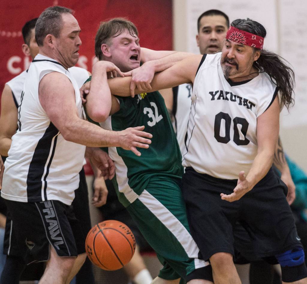 Sitkas Sean Joslyn, center, gets pinned between Yakutats Bob Rockwood, left, and Gary Klushkan in a masters bracket game at the Juneau Lions Club 73rd Annual Gold Medal Basketball Tournament at Juneau-Douglas High School: Yadaa.at Kalé on Wednesday, March 20, 2019. Yakutat won 66-49. (Michael Penn | Juneau Empire)