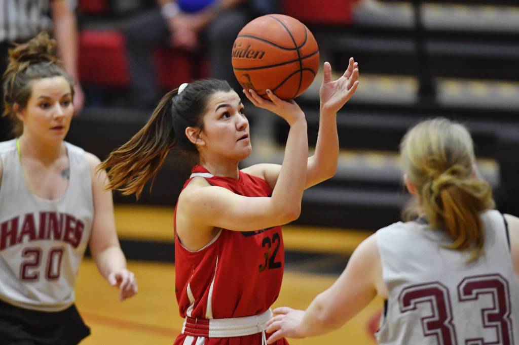 Hoonahs Ronnie Roberts shoots between Haines Sam Clay, left, and Sabrina Stickler in their womens bracket game at the Gold Medal Basketball Tournament on Thursday, March 21, 2019. (Michael Penn | Juneau Empire)