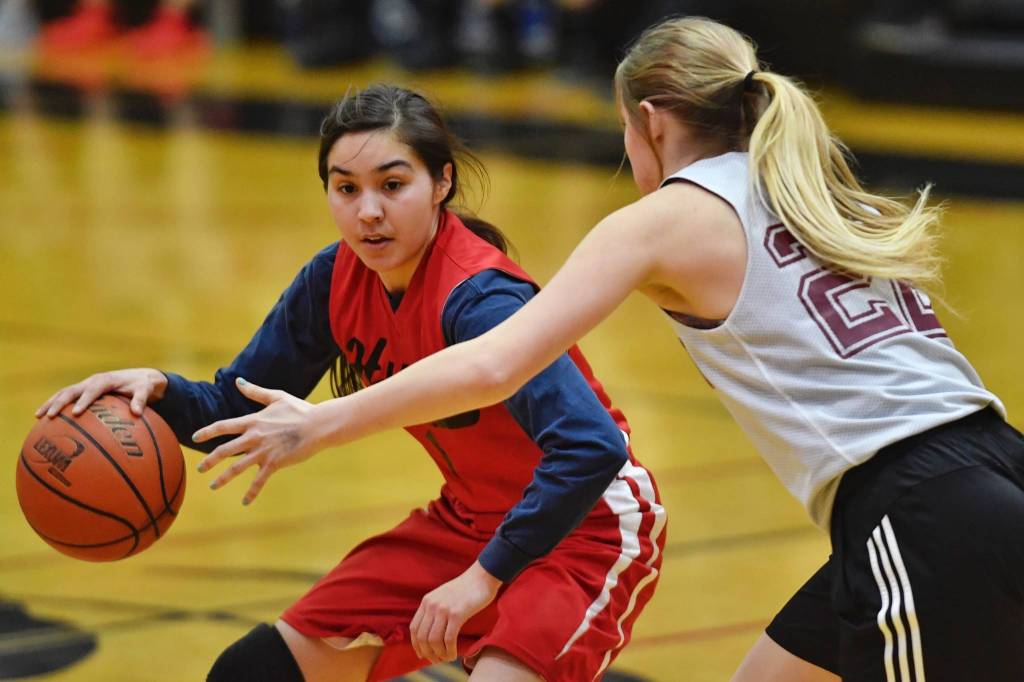 Hoonahs Melissa Fisher dribbles under pressure by Haines Liz Segars in the womens bracket game at the Gold Medal Basketball Tournament on Thursday, March 21, 2019. (Michael Penn | Juneau Empire)