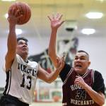 Yakutats Jerry Riddlington, left, lays the ball up against Hoonahs James Mercer in the Masters bracket game at the Gold Medal Basketball Tournament on Thursday, March 21, 2019. (Michael Penn | Juneau Empire)