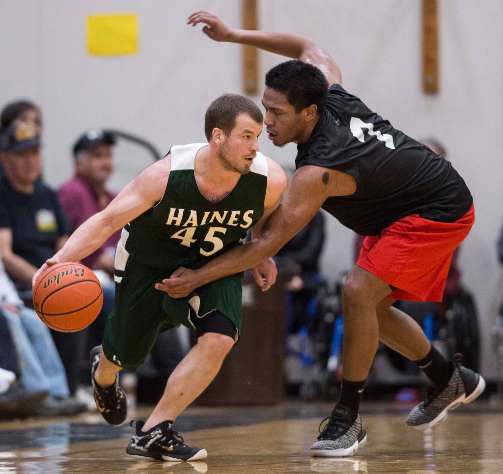 Hydaburgs Christian Nickerson, right, puts pressure on Haines Brian Combs during their B bracket game at the Juneau Lions Club 73rd Annual Gold Medal Basketball Tournament at Juneau-Douglas High School: Yadaa.at Kalé on Thursday, March 21, 2019. Haines won 78-52. (Michael Penn | Juneau Empire)