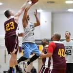 Klukwans Michael Ganey, left, blocks a shot by Filcoms Larry Cooper in their C bracket game at the Gold Medal Basketball Tournament on Thursday, March 21, 2019. (Michael Penn | Juneau Empire)