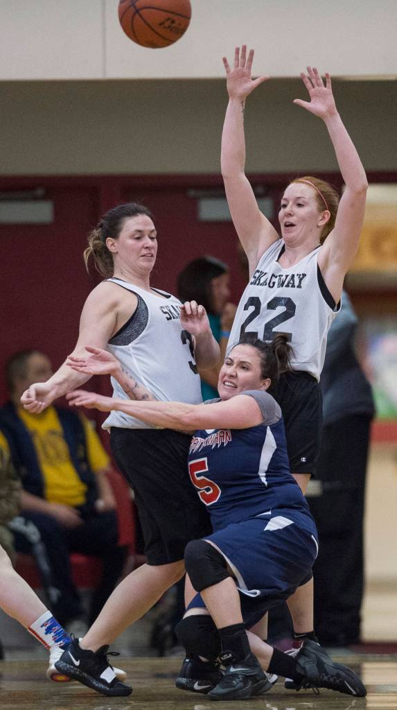 Yakutats Kim Buller, below, crashes into Skagways Tiffanie Ames, left, and Jesse Ellis during the womens bracket game at the Gold Medal Basketball Tournament on Thursday, March 21, 2019. (Michael Penn | Juneau Empire)