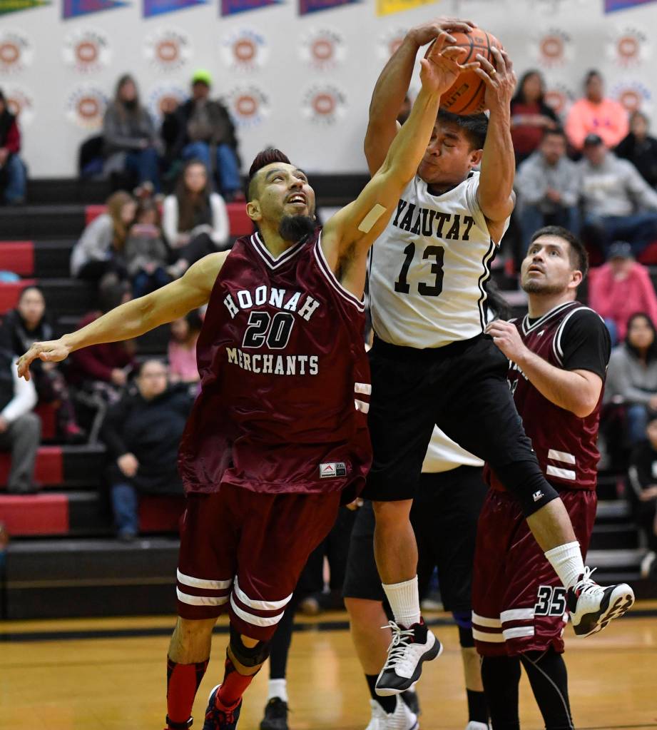 Yakutats Jerry Riddington, center, rebounds between Hoonahs Marti Fred, left, and Kamal Lindoff in the Masters bracket game at the Gold Medal Basketball Tournament on Thursday, March 21, 2019. (Michael Penn | Juneau Empire)