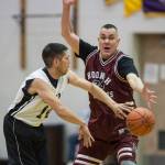 Yakutats Ralph Johnson, left, passes against Hoonahs James Mercer in the Masters bracket game at the Gold Medal Basketball Tournament on Thursday, March 21, 2019. (Michael Penn | Juneau Empire)