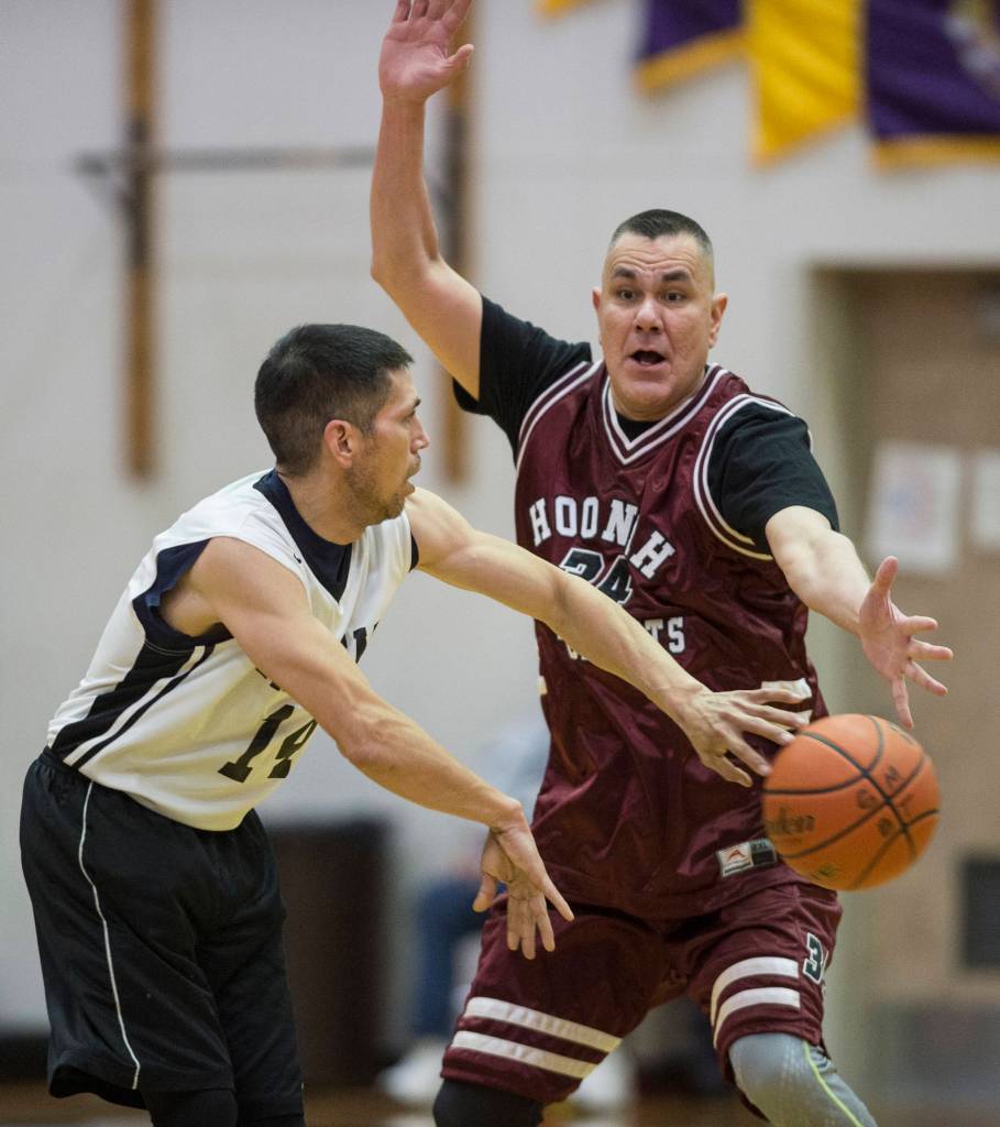 Yakutats Ralph Johnson, left, passes against Hoonahs James Mercer in the Masters bracket game at the Gold Medal Basketball Tournament on Thursday, March 21, 2019. (Michael Penn | Juneau Empire)
