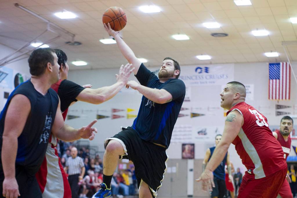 Hydaburgs Eric Hamilton drives to the basket as Hoonahs Jeremy Martin looks on in their C bracket game at the Lions Club Gold Medal Basketball Tournament on Thursday, March 21, 2019. (Nolin Ainsworth | Juneau Empire)