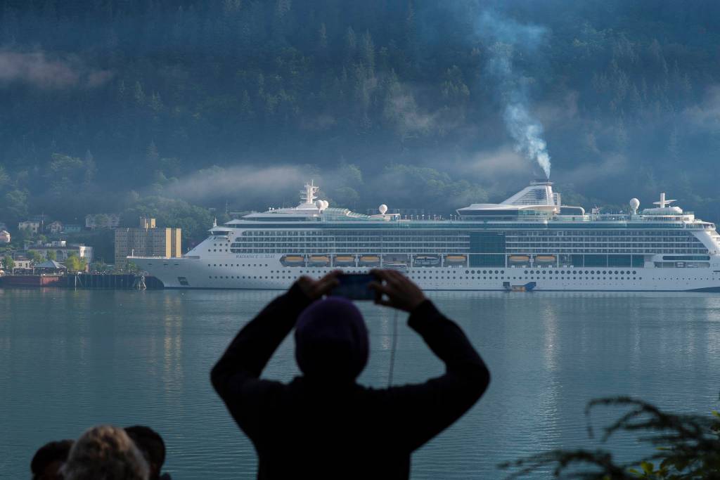 A cruise ship passenger photographs the Radiance of the Seas in Juneaus downtown harbor on Tuesday, August 29, 2017. (Michael Penn | Juneau Empire File)