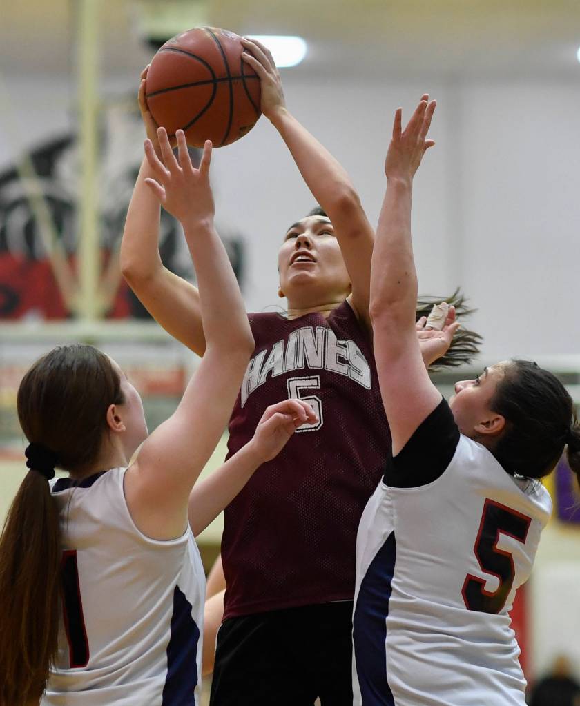 Haines Fran Daly, center, shoots over Yakutats Shaye Jensen, left, and Kim Buller during their womens bracket game at the Juneau Lions Club 73rd Annual Gold Medal Basketball Tournament at Juneau-Douglas High School on Friday, March 22, 2019. Haines won 64-48. (Michael Penn | Juneau Empire)