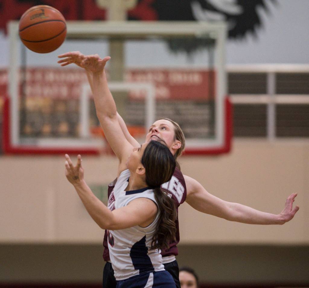 Haines Liz Segars, back, and Yakutats Lorena Williams tip off during their womens bracket game at the Juneau Lions Club 73rd Annual Gold Medal Basketball Tournament at Juneau-Douglas High School on Friday, March 22, 2019. Haines won 64-48. (Michael Penn | Juneau Empire)