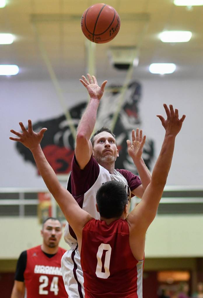 Klukwans Andrew Friske shoot over Hoonahs Anthony Lindoff during their C bracket game at the Juneau Lions Club 73rd Annual Gold Medal Basketball Tournament at Juneau-Douglas High School on Friday, March 22, 2019. Klukwan won 88-67. (Michael Penn | Juneau Empire)
