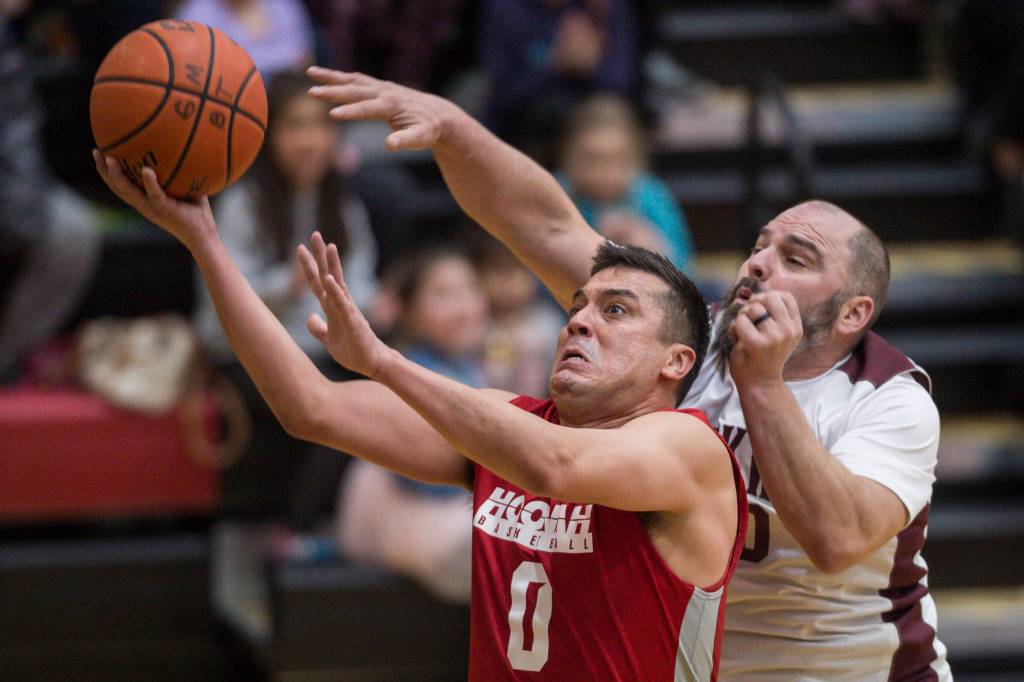 Hoonahs Anthony Lindoff, left, scores in front of Klukwans Stuart DeWitt during their C bracket game at the Juneau Lions Club 73rd Annual Gold Medal Basketball Tournament at Juneau-Douglas High School on Friday, March 22, 2019. Klukwan won 88-67. (Michael Penn | Juneau Empire)