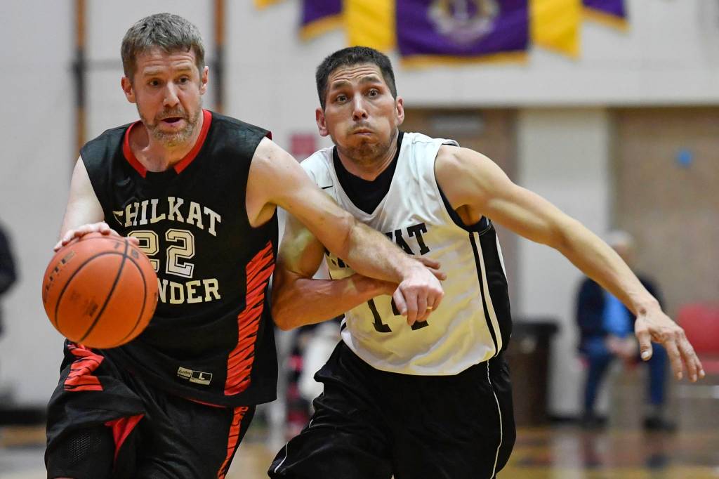 Klukwans Dave Buss drives to the basket against Yakutats Ralph Johnson during their Masters bracket game at the Juneau Lions Club 73rd Annual Gold Medal Basketball Tournament at Juneau-Douglas High School on Friday, March 22, 2019. Klukwan won 63-58. (Michael Penn | Juneau Empire)