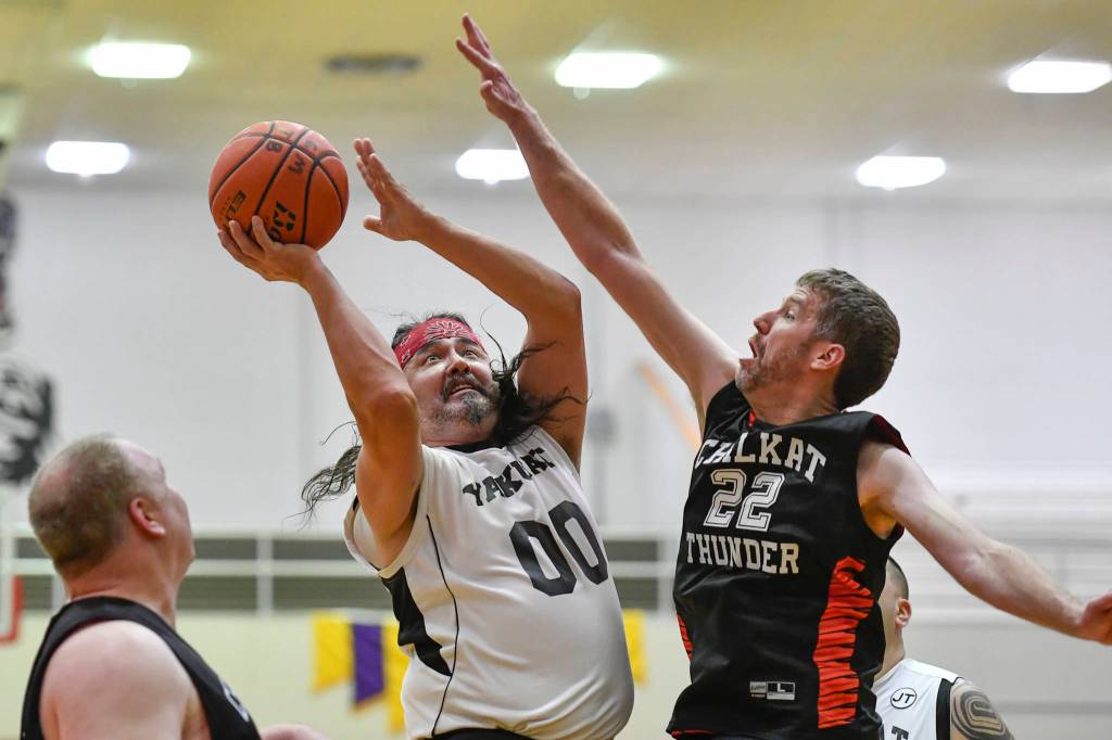 Yakutats Gary Klushkan, center, shoot against Klukwans Dave Buss during their Masters bracket game at the Juneau Lions Club 73rd Annual Gold Medal Basketball Tournament at Juneau-Douglas High School on Friday, March 22, 2019. Klukwan won 63-58. (Michael Penn | Juneau Empire)