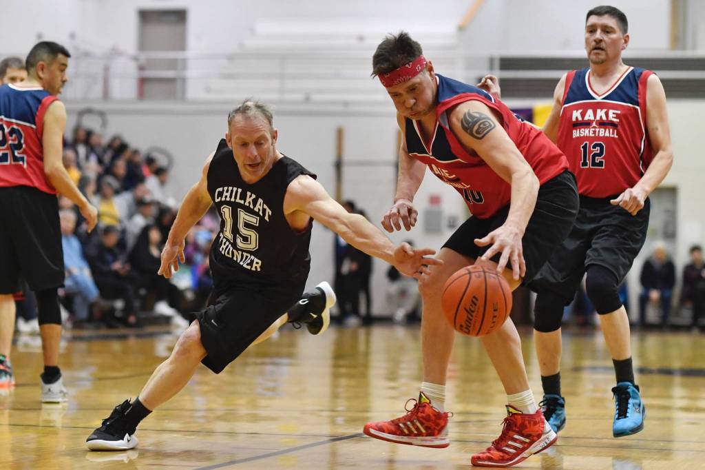 Kakes Nick Davis, right, takes the ball away from Klukwans Pete Dohrn in the Masters final at the Gold Medal Basketball Tournament on Saturday, March 23, 2019. (Michael Penn | Juneau Empire)