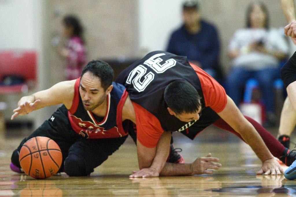 Kakes Rudy Bean left, tangles with Klukwans Neil Erickson in the Masters final at the Gold Medal Basketball Tournament on Saturday, March 23, 2019. (Michael Penn | Juneau Empire)