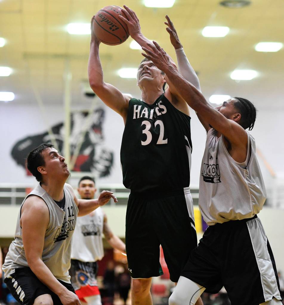 Haines Tyler Swinton, center, shoots between Angoons John Croasmun Jr., left, and Clayton Edwin in the B final at the Gold Medal Basketball Tournament on Saturday, March 23, 2019. Haines won 88-80. (Michael Penn | Juneau Empire)