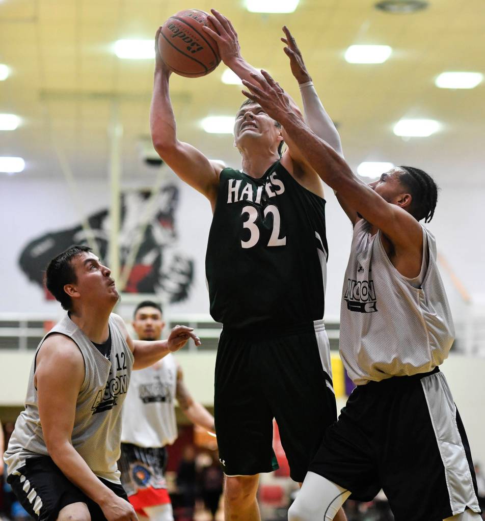 Haines Tyler Swinton, center, shoots between Angoons John Croasmun Jr., left, and Clayton Edwin in the B final at the Gold Medal Basketball Tournament on Saturday, March 23, 2019. Haines won 88-80. (Michael Penn | Juneau Empire)