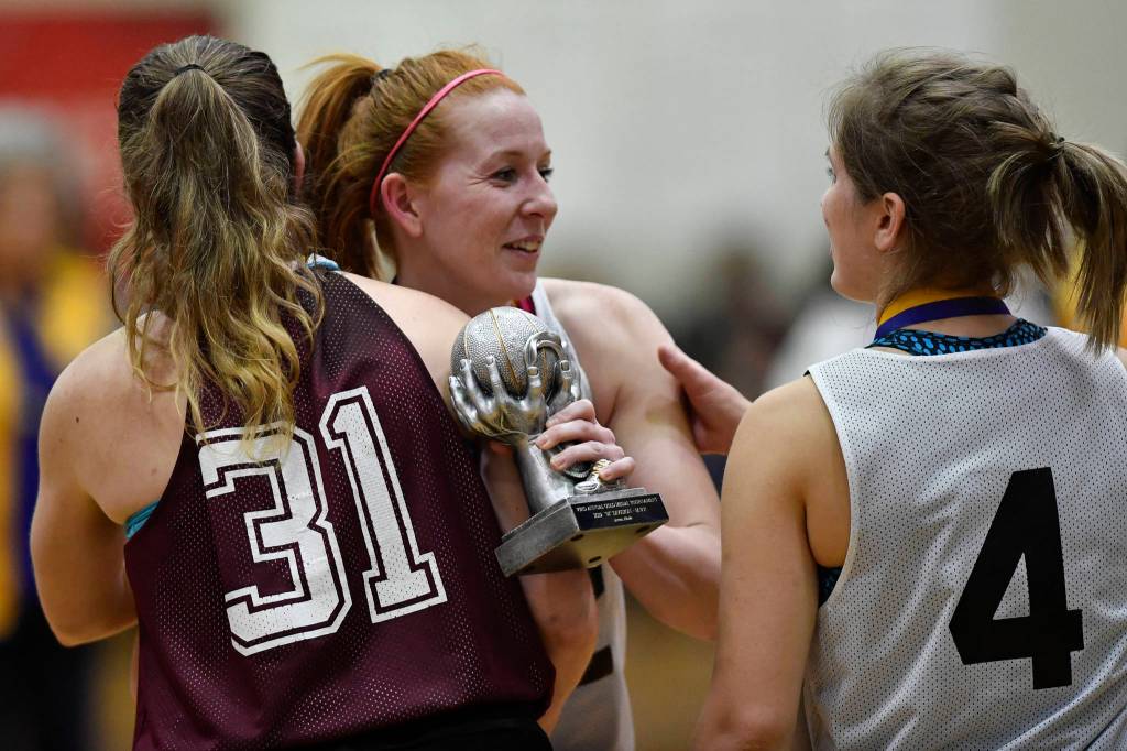 Skagway Jesse Ellis, center, receives congratulations from teammate Kaitlyn Jeron, right, and Haines Rachel Brittenham after receiving the MVP award in the womens final at the Gold Medal Basketball Tournament on Saturday, March 23, 2019. Skagway won 58-49. (Michael Penn | Juneau Empire)