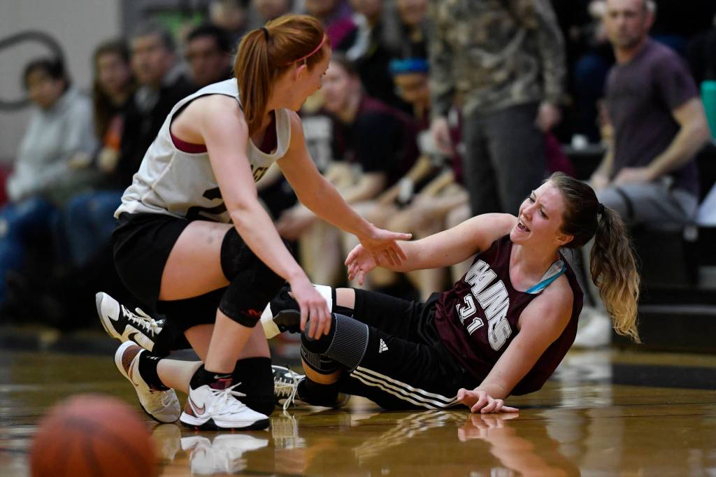 Skagways Jesse Ellis, left, helps Haines Rachel Brittenham up after they had a mid-court collision in the womens final at the Gold Medal Basketball Tournament on Saturday, March 23, 2019. Skagway won 58-49. (Michael Penn | Juneau Empire)