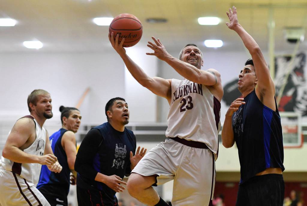 Klukwans Michael Ganey, center, shoots against Hydaburgs Ben Young in the C final at the Gold Medal Basketball Tournament on Saturday, March 23, 2019. Hydaburg won 93-81. (Michael Penn | Juneau Empire)