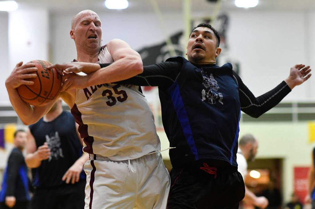 Klukwans Brian Friske, left, battles Hydaburgs Harold Dilts in the C final at the Gold Medal Basketball Tournament on Saturday, March 23, 2019. Hydaburg won 93-81. (Michael Penn | Juneau Empire)