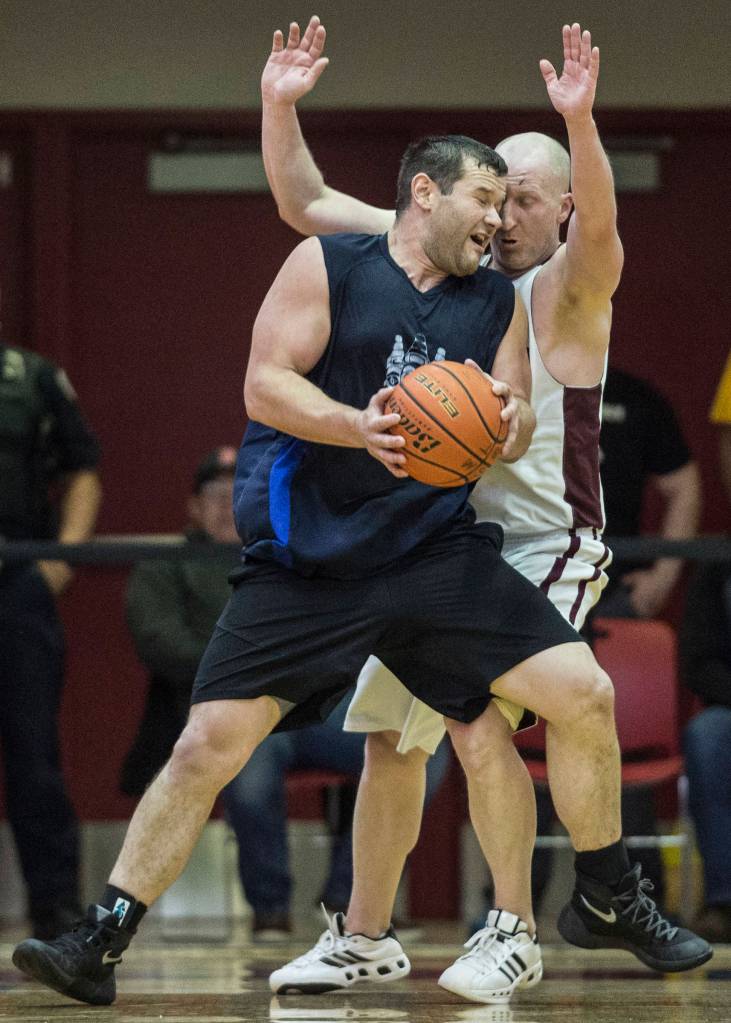 Hydaburgs Fred Hamilton and Klukwans Brian Friske knock heads in the C final at the Gold Medal Basketball Tournament on Saturday, March 23, 2019. Hydaburg won 93-81. (Michael Penn | Juneau Empire)