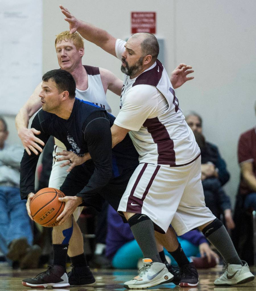 Klukwans Jesse McGraw, center, and Stuart DeWitt, right, pressure Hydaburgs Kevin Young in the C final at the Gold Medal Basketball Tournament on Saturday, March 23, 2019. Hydaburg won 93-81. (Michael Penn | Juneau Empire)