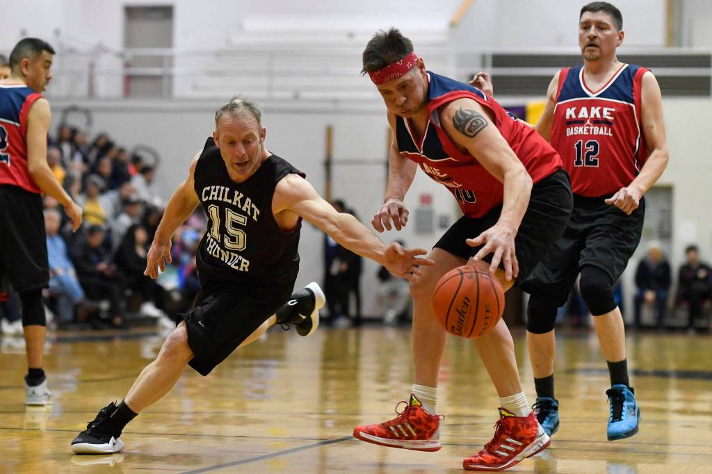 Kakes Nick Davis, right, takes the ball away from Klukwans Pete Dohrn in the Masters final at the Gold Medal Basketball Tournament on Saturday, March 23, 2019. Kake won 75-64. (Michael Penn | Juneau Empire)