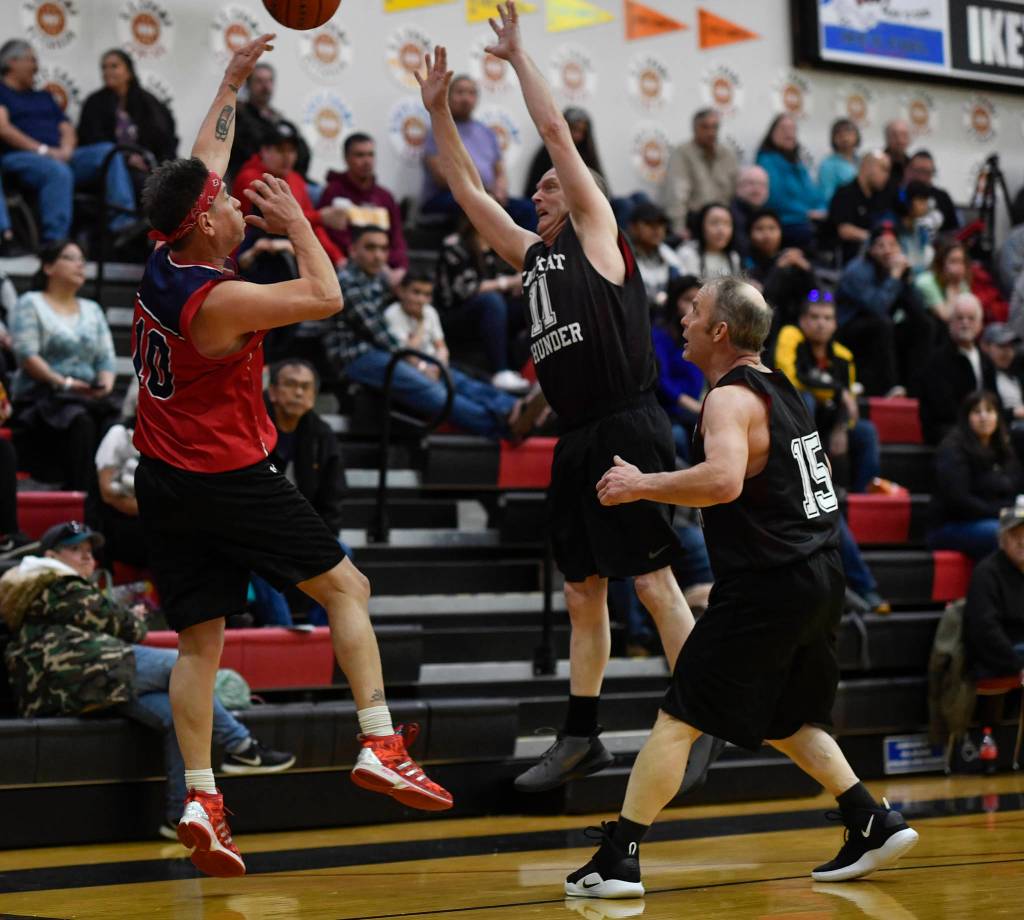 Kakes Lloyd Davis, left, passes against pressure by Klukwans Don Nash, center, and Pete Dohrn in the Masters final at the Gold Medal Basketball Tournament on Saturday, March 23, 2019. Kake won 75-64. (Michael Penn | Juneau Empire)