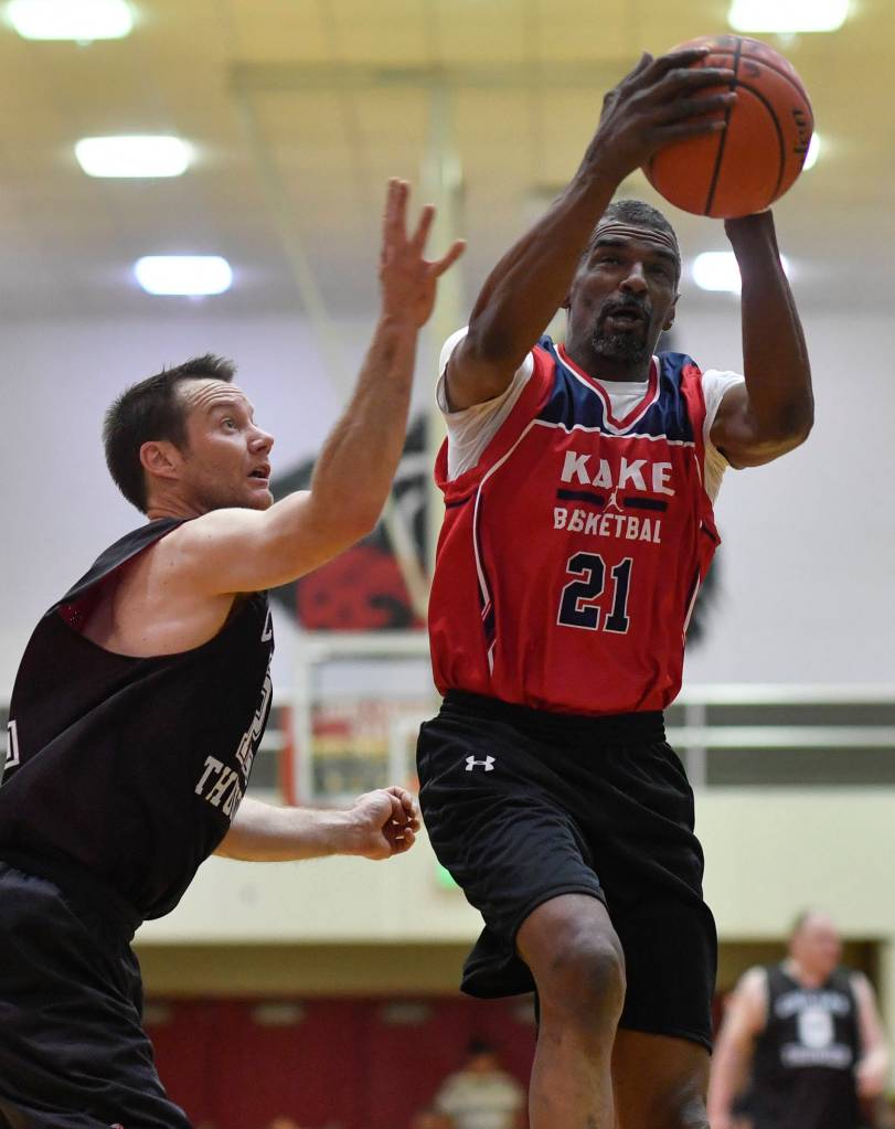 Kakes Kip Howard, right, drives to the basket against Klukwans Scott Forbes in the Masters final at the Gold Medal Basketball Tournament on Saturday, March 23, 2019. Kake won 75-64. (Michael Penn | Juneau Empire)