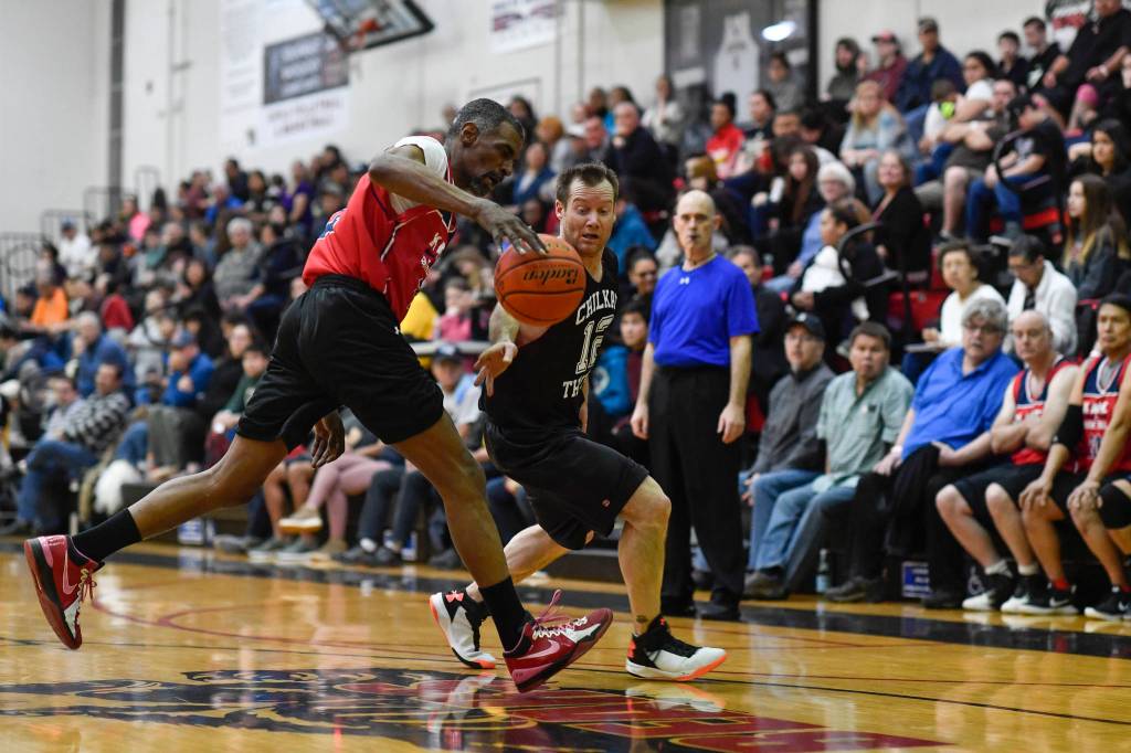 Kakes Kip Howard, left, chases a loose ball agianst Klukwans Scott Forbes in the Masters final at the Gold Medal Basketball Tournament on Saturday, March 23, 2019. Kake won 75-64. (Michael Penn | Juneau Empire)