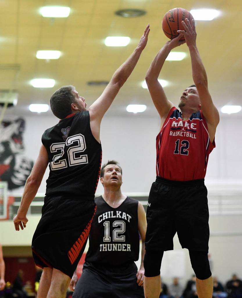 Kakes Lloyd Davis, right, shoots over Klukwans Dave Buss in the Masters final at the Gold Medal Basketball Tournament on Saturday, March 23, 2019. Kake won 75-64. (Michael Penn | Juneau Empire)