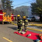 Firefighters are seen at the scene of a house fire on North Douglas Highway on Thursday, March 28, 2019. (Michael Penn | Juneau Empire)