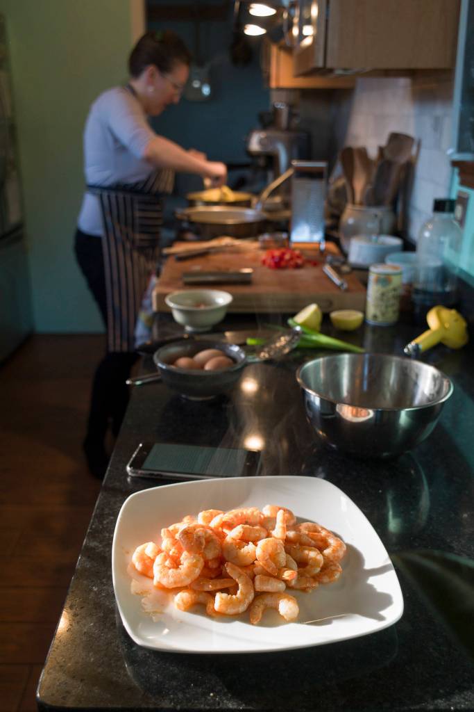 Erin Anais Heist prepares a spaghetti squash, prawns, bacon and egg breakfast dish in her home kitchen on Thursday, March 28, 2019. (Michael Penn | Juneau Empire)