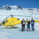 Robert Venables, Southeast Conference executive director, Meilani Schijvens, Rain Coast Data director and Alec Mesdag, incoming president of the Southeast Conference Board of Directors show off the Southeast Alaska 2020 Economic Plan, the NADO award and Southeast Alaska by the Numbers publication on the Juneau icefield. (Courtesy Photo | Heather Holt)